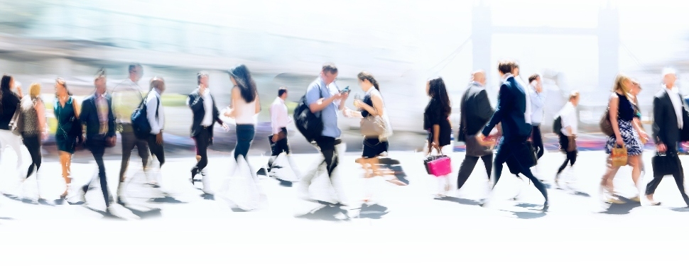 People walking outdoors in different directions in a city