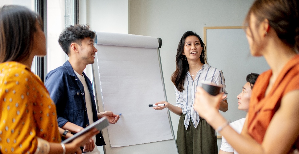 Group of office workers brainstorming ideas using a whiteboard