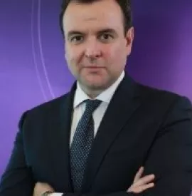 Person in a suit with a purple background.