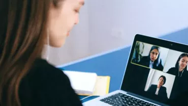 Person participating in a video call on a laptop