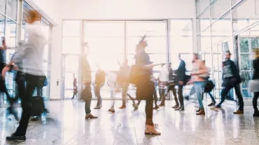 Blurry crowd moving through a lobby.