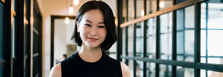 A female professional smiling, on a office background